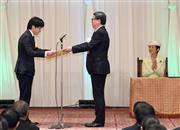 芦立訓・文部科学審議官（中央）から文部科学大臣賞の賞状を授与される東京大学大学院の山田駿介さん＝１１日午前、東京・元赤坂の明治記念館