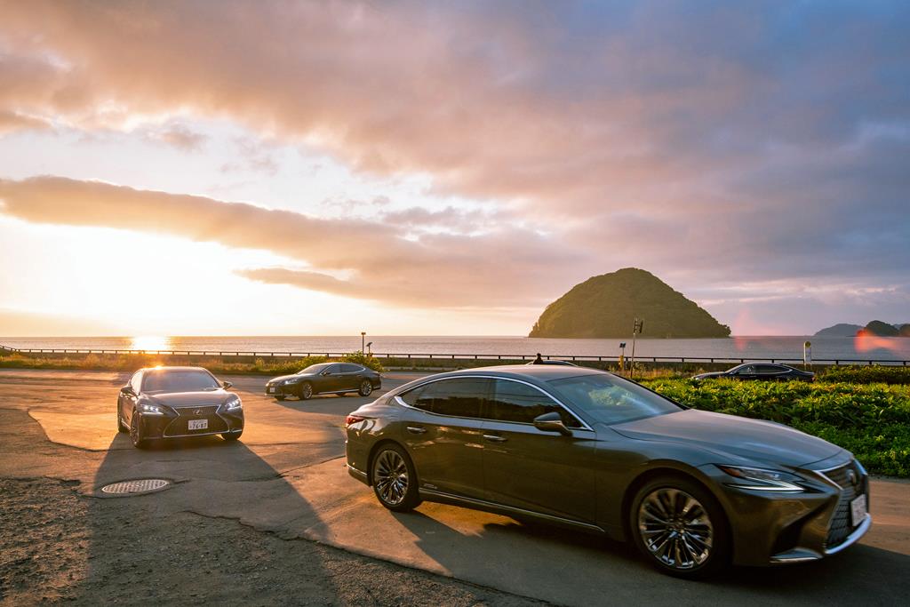 夕日に照らされた湯ノ島を眺めながら、レクサスの後席に座って夜のイベントに向かう