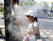 熱中症対策でミストを浴びる女の子＝岐阜県多治見市
