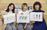 生理用品の外装デザインの案を持つ菅本裕子さん（左）ら