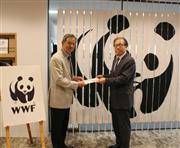 ＷＷＦジャパンの末吉竹二郎会長（左）に寄付金を手渡すフジサンケイグループの小川晋一事務局長　＝20日、東京都港区の公益財団法人世界自然保護基金（ＷＷＦ）ジャパン