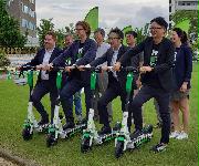 ＬＩＭＥの電動キックボードの実験に参加した、同社でアジア太平洋地域の政府戦略責任者を務めるミチェル・プライスさん（左端）ら＝７日、福岡市東区