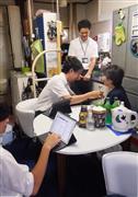 中央の医師と３人チームで動くＰＡ。患者宅での会話を入力（手前）、側に控えてサポートする（奥）＝東京都練馬区