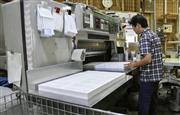 パンフレットの製本作業をする経営者の男性＝１３日、埼玉県川越市