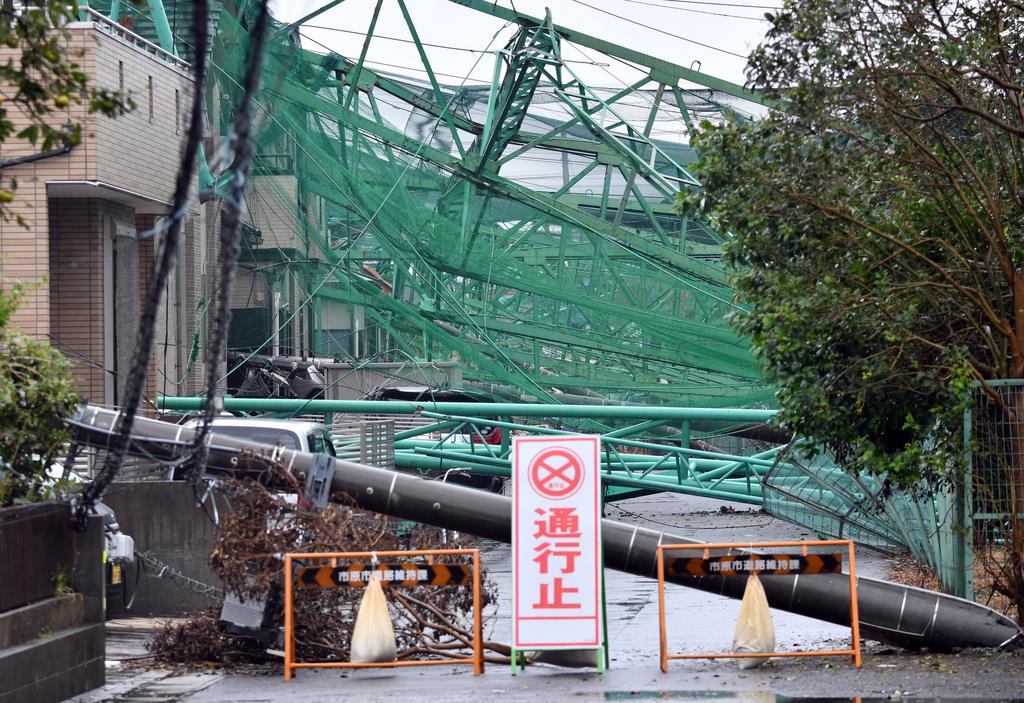 台風１５の影響で住宅に倒れたゴルフ練習場の鉄柱とネット＝１６日午前、千葉県市原市（鴨川一也撮影）