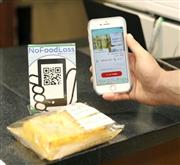 アプリ「ノー・フード・ロス」を使ってコンビニで買い物をする会員＝７月、東京・浜松町