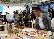 分身ロボット「OriHime-D」から接客を受ける作家の乙武洋匡さん（右）＝７日午後、東京都千代田区の大手門タワー・ＪＸビル（桑原雄尚撮影）