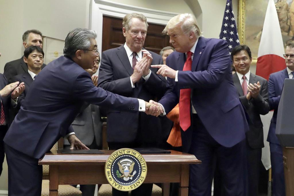 ７日、米ホワイトハウスで行われた日米貿易協定の署名式に出席した（手前左から）杉山晋輔駐米大使、ライトハイザー通商代表、トランプ大統領（ＡＰ）