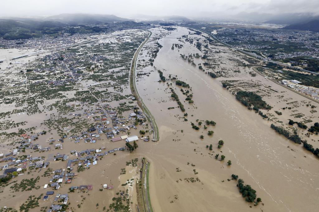 台風１９号による大雨で増水し氾濫した千曲川。中央左は決壊した堤防＝１３日午前８時１５分、長野市穂保