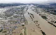 台風１９号による大雨で増水し氾濫した千曲川。中央左は決壊した堤防＝１３日午前８時１５分、長野市
