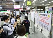 台風19号の接近に伴い、掲示された運休情報などを見る人たち＝2019年10月11日、埼玉県川口市のJR川口駅 - 写真＝時事通信フォト