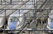 水に漬かった北陸新幹線車両を点検する作業員＝１８日午後、長野市の長野新幹線車両センター