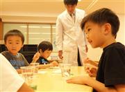 フェルトの上にスポイトで水を垂らして、竹串でつついてみる。表面張力の存在を確かめる実験＝東京都港区の「にじのいるか保育園　芝浦」（重松明子撮影）