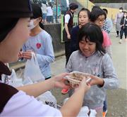 すき家のスタッフから牛丼を受け取る丸森小の児童たち＝３０日、宮城県丸森町（塔野岡剛撮影）