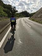 「国境サイクリングIN対馬」で上り坂を走るサイクリスト　＝10月19日、長崎県対馬市