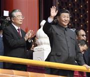 　中国建国７０年の記念式典で手を振る習近平国家主席。左は胡錦濤前国家主席＝北京の天安門（共同）