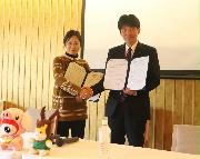 覚書を締結しウェイボ側の責任者と握手を交わす山本一太知事（右）＝６日、東京都港区（県提供）
