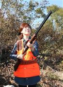 散弾銃を構える和歌山県猟友会女性部の溝部名緒子さん＝和歌山市の紀の川