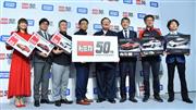 「トミカ」の５０周年記者発表会で撮影に応じるタカラトミーの富山幹太郎会長（中央右）ら＝１５日、東京都品川区