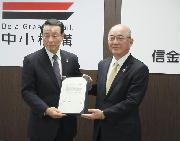 　包括提携の合意書を手にする信金中央金庫の柴田弘之理事長（右）と中小企業基盤整備機構の豊永厚志理事長＝２８日午前、東京都内