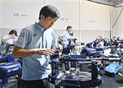 ヨネックスのストリンギングチームの一員として、全豪オープンの会場で作業をする玉川裕康さん＝１７日、メルボルン（共同）