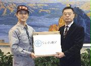 　在日中国大使館の職員（右）にマスクを手渡す東京都港区の職員。マスクの価格が高騰している＝１月３１日