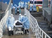 中国では新型コロナウイルスの感染拡大が続いている。突貫工事で新設された「火神山医院」に新型肺炎患者を運び込む医療関係者ら＝４日、中国・武漢　（新華社＝共同）