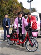 実証実験に使われる電動アシスト付き自転車の説明を受ける高橋靖・水戸市長（中央）＝１５日午前、水戸市（三浦馨撮影）