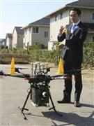 小型無人機ドローンが配送したバナナを手に取る茨城県つくば市の五十嵐立青市長＝つくば市