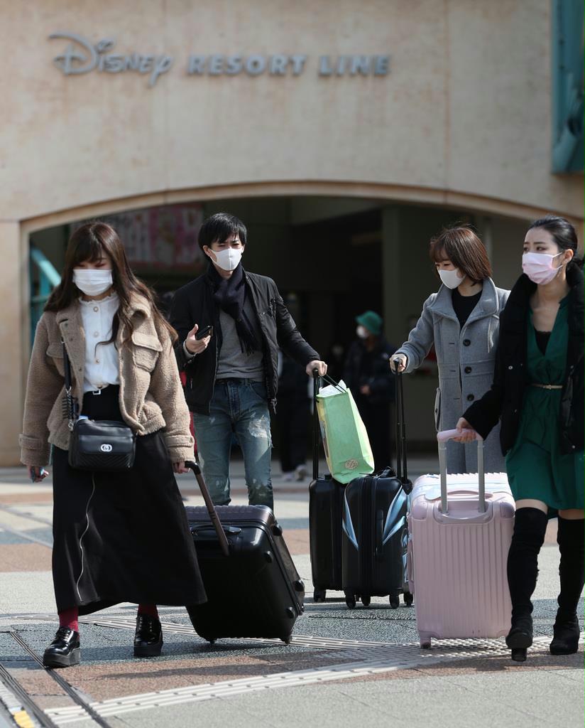 新型コロナウイルスの影響で、臨時休園している東京ディズニーランド。大きな荷物を持ち、駅へ向かう人の姿がみられた＝２月２９日午後、千葉県浦安市（佐藤徳昭撮影）