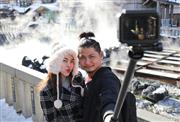 草津温泉の名物・湯畑を背に記念撮影するタイ人観光客。草津は外国人からも支持を得ている＝１月２９日、草津町（福島範和撮影）