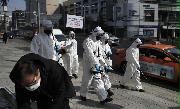 ６日、韓国・ソウルの路上で消毒剤をまく韓国の兵士ら(AP)