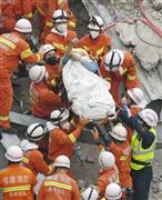 中国福建省泉州市のホテル倒壊現場から負傷者を搬送する消防隊員ら＝１０日（新華社＝共同）