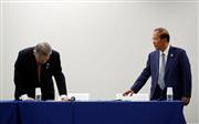 東京五輪の延期を受け、記者会見でうなだれる森喜朗・東京五輪・パラリンピック組織委員会会長（左）＝２４日夜、東京都内（ロイター）