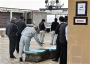 岡山市役所の屋上で一服する職員ら