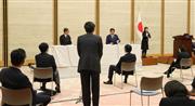 緊急事態宣言を発令し会見で記者団の質問に答える安倍晋三首相（右）＝７日午後、首相官邸（春名中撮影）