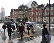 通勤する人たち。感染抑止に向け、政府は「出勤７割減」を求めている＝１３日午前、ＪＲ東京駅前