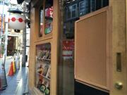 出店荒らしの被害に遭ったお好み焼屋の入口。ガラスが割られた部分は板で覆われていた＝１４日、大阪市中央区