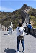 北京市郊外にある万里の長城の代表的な観光スポット「八達嶺」で、記念撮影するマスク姿の観光客＝２５日（三塚聖平撮影）