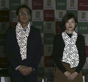 新潟県五泉市の発表会で、反射機能付きマフラーを披露する職員ら