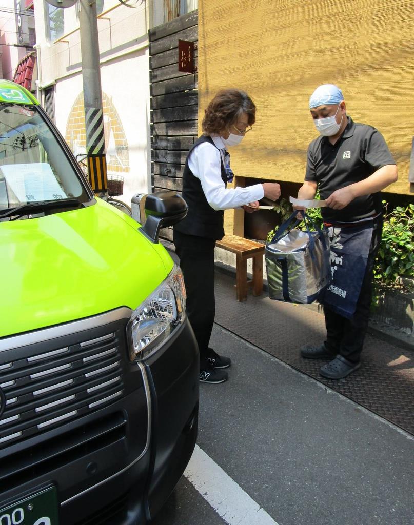 料理を飲食店で受け取り、宅配に向かうタクシー運転手（左）＝２日、静岡市葵区