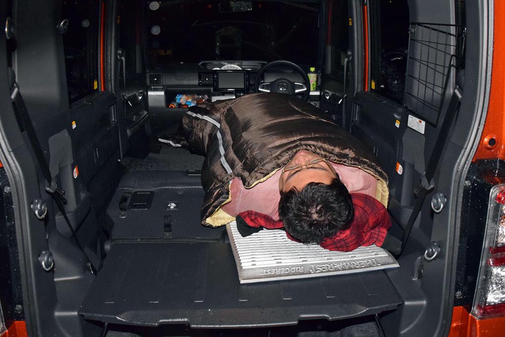 寝袋に収まる杉渕。写真のように、下半身を車内の中央寄りにしてに寝ると、シートの段差を感じにくいそうだ。そうなると、大人2人が並んで寝るスペースはない