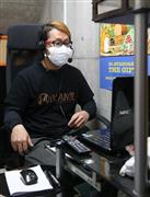 番台にモニターが設置されており、別室で画面越しに対応する大坪学さん＝大阪市平野区の入船温泉（寺口純平撮影）