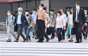 ＪＲ品川駅周辺で、マスク姿で職場に向かう人たち＝２６日午後、東京都港区（宮崎瑞穂撮影）