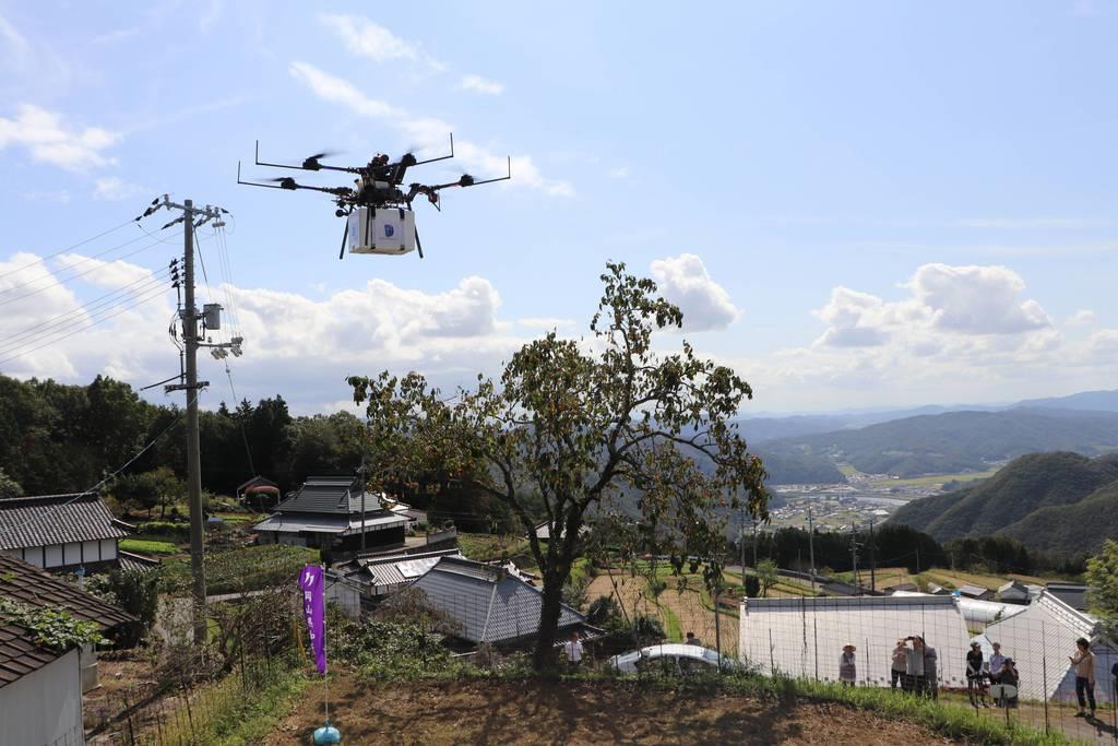 和気町・南山方区の集落を飛ぶドローン＝昨年１０月６日、岡山県和気町