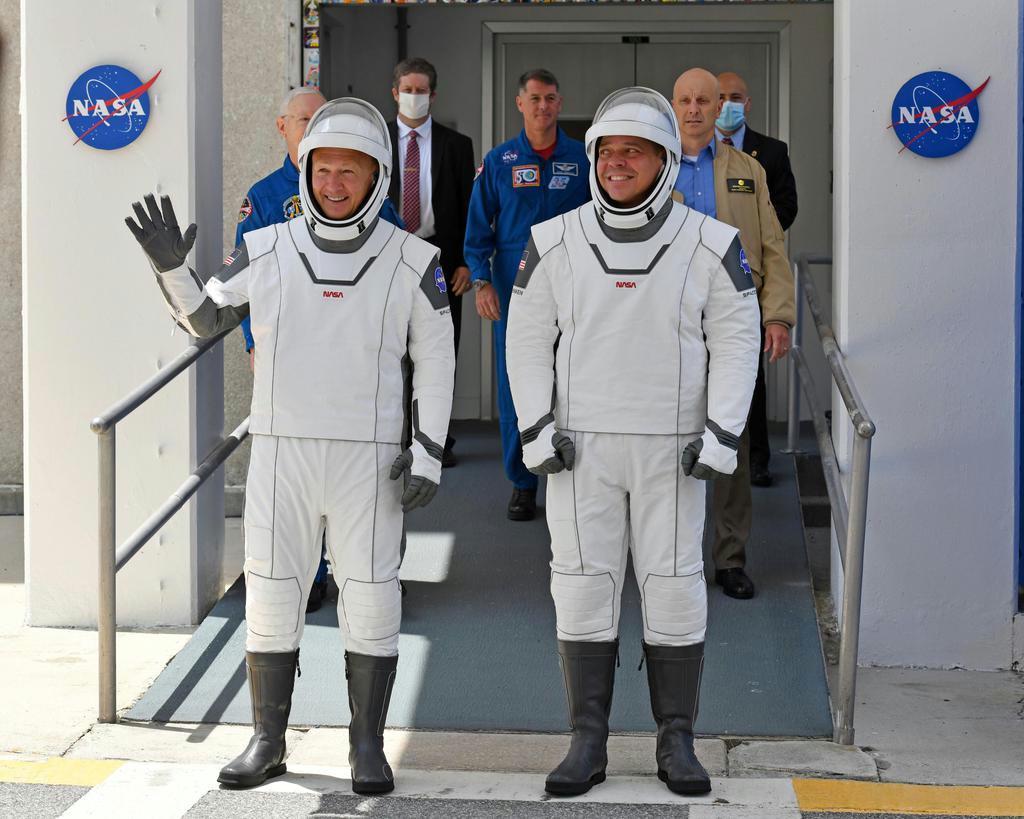 宇宙船「クルードラゴン」に乗り込むため、ケネディ宇宙センターの施設を出発するＮＡＳＡのダグラス・ハーリー飛行士（左）とロバート・ベンケン飛行士＝３０日、米フロリダ州ケープカナベラル（ＵＰＩ＝共同）