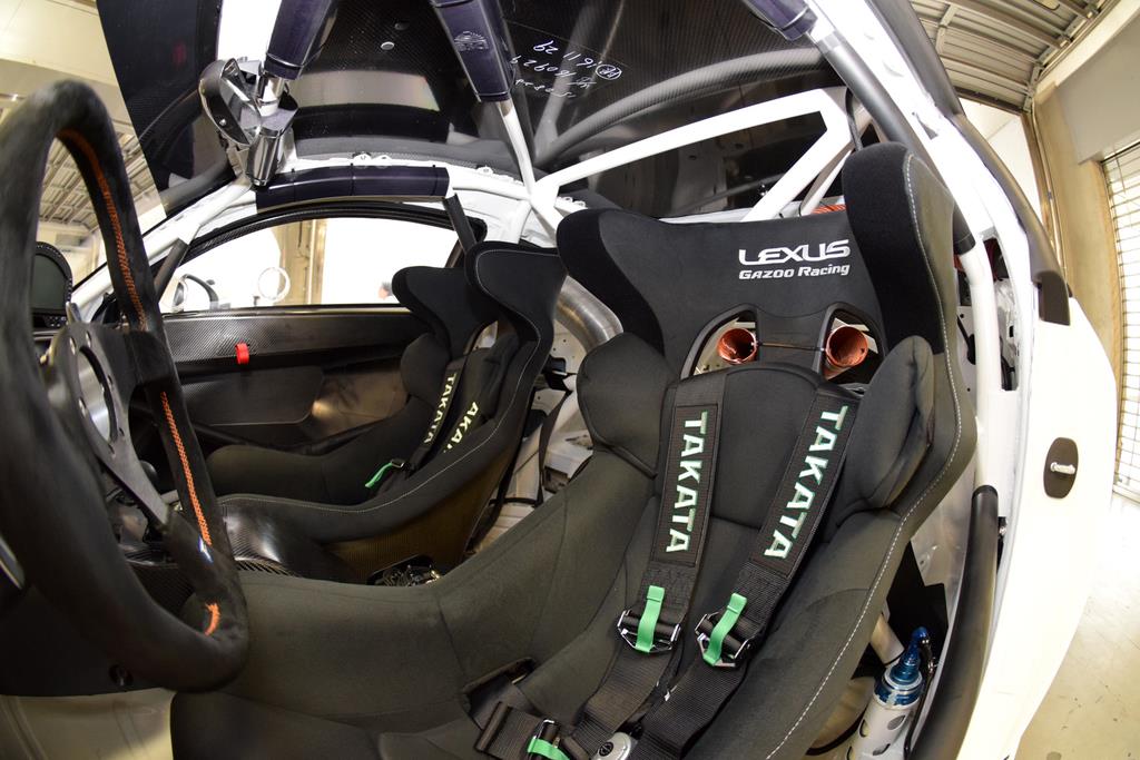 フルバケットシートと、ドライバーをシートに固定する5点式シートベルト。ドライバーの肩越しに車内を冷却するクーリング用パイプも見える
