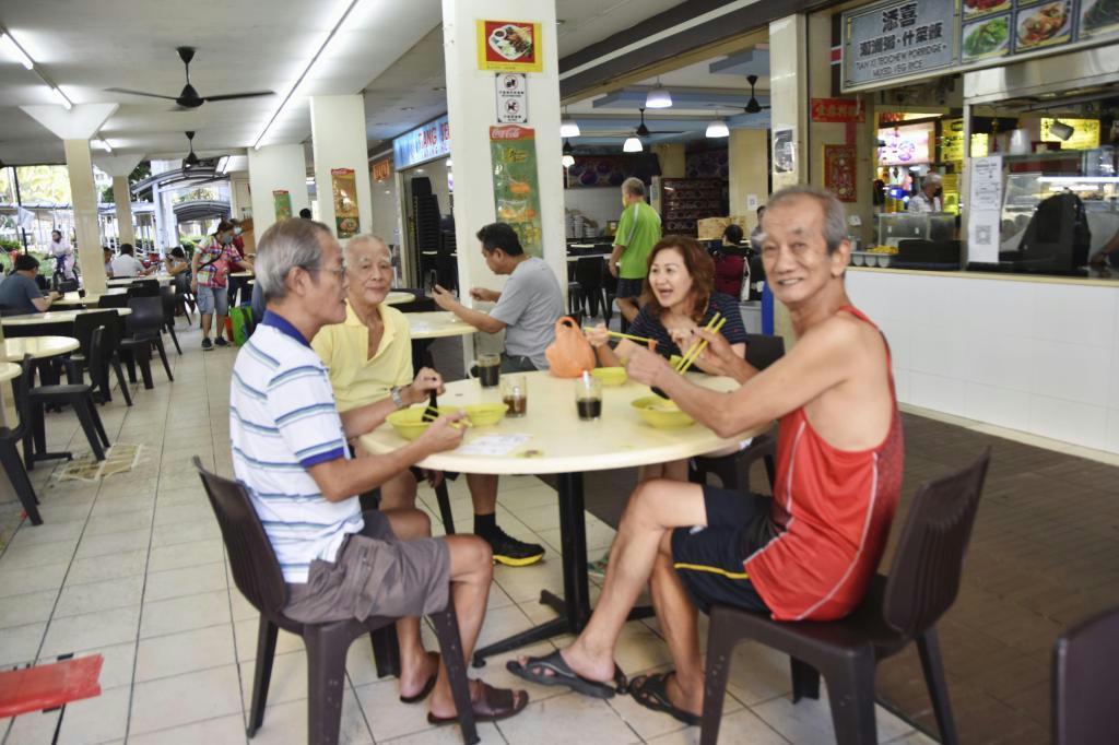 経済活動が本格的に再開されたシンガポールで、友人と朝食を楽しむチュア・ブンアンさん（右端、共同）