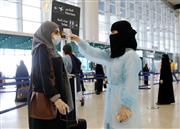 サウジアラビアの空港で検温を受ける女性（ロイター＝共同）