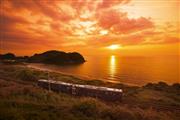 夕景を走り抜ける観光列車「おれんじ食堂」＝（肥薩おれんじ鉄道提供）